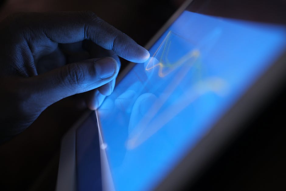 Close-up of a hand interacting with a touch screen tablet, showcasing modern technology use